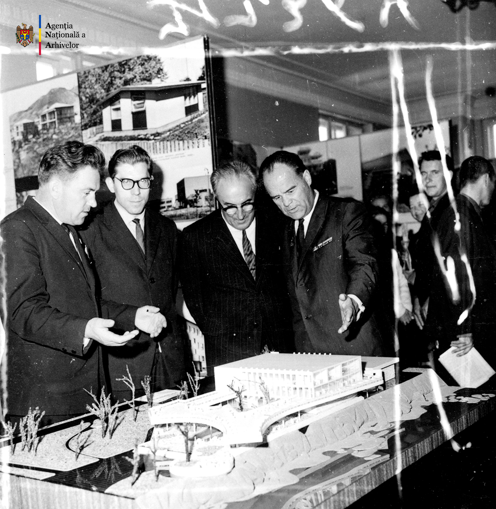 Un grup de arhitecţi sovietici în faţa unei machete din expoziţia proiectelor de construcţii săteşti prezentate în cadrul Plenarei a VII-a a conducerii Uniunii Arhitecţilor din URSS. Primul din dreapta, Valentin Mednec, or. Krasnodar, Federaţia Rusă, 10 octombrie 1968. ANA, fototeca, c. a. 1 – 5648.
