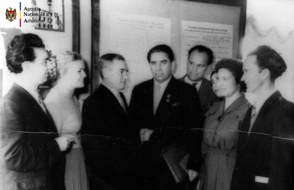 Un grup de delegaţi la Congresul al VI-lea al Arhitecţilor din RSSM, în timpul unei pauze între şedinţele întrunirii, al cincilea din stânga, Valentin Mednec, or. Chişinău, anul 1958. ANA, fototeca, c. a. 21/241.
